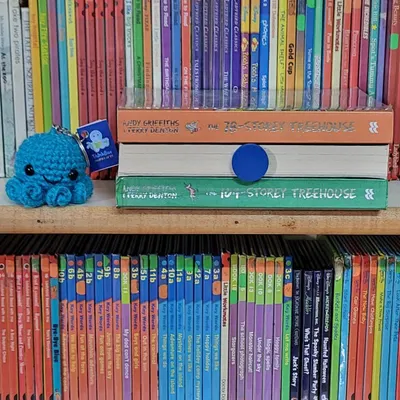 A peek at our shelves, featuring the hilarious "Treehouse" series and a cute handmade octopus keychain. Our library is filled with treasures waiting to be discovered.