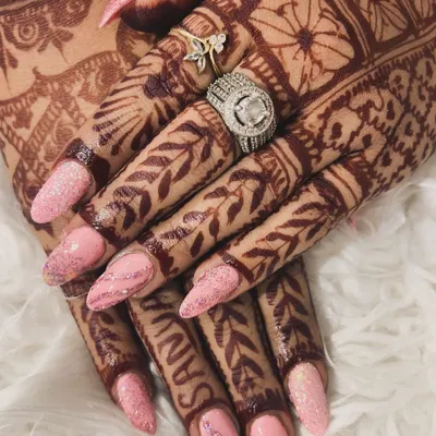 A gorgeous set for a bride, perfectly matching her beautiful henna. These long, almond-shaped nails feature a soft pink glitter base that adds a delicate sparkle for the big day.