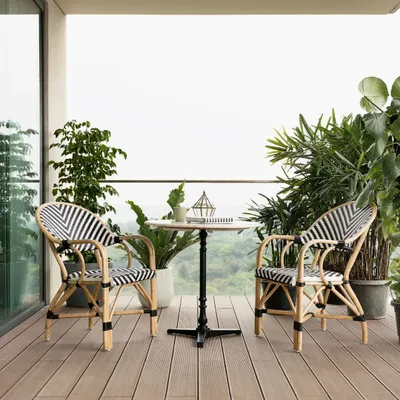 This balcony is the perfect spot to relax and enjoy the view. I chose these comfortable and stylish black-and-white bistro chairs and a small cafe table to create an inviting outdoor lounge area, surrounded by lush plants.