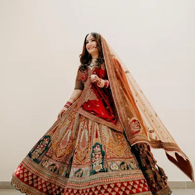 A full-length shot of the bride twirling in her magnificent multi-colored lehenga, a picture of pure grace and happiness.