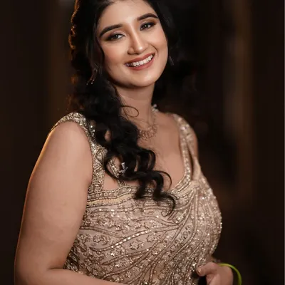 A soft and romantic engagement makeup look. The focus is on glowing skin, gentle waves in the hair, and a natural lip color.