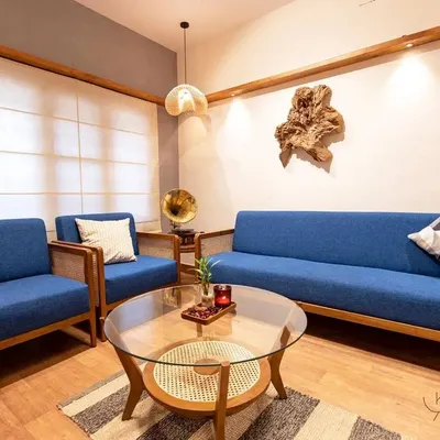 This complete living room set, featuring a five-seater sofa and matching armchairs in a striking blue fabric, shows how I blend classic teak and rattan construction with modern comfort. The glass-topped coffee table adds a final touch of elegance.