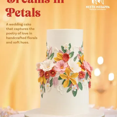 This wedding cake, 'Dreams in Petals', captures the poetry of love with a wreath of handcrafted sugar flowers in soft, romantic hues. The design is a celebration of nature's beauty, perfect for a garden wedding.