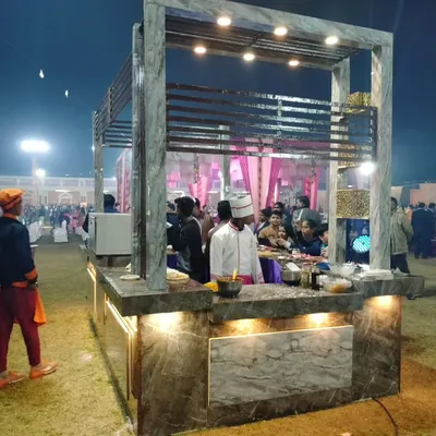 My modern live food station in action at an outdoor night event. A chef prepares fresh dishes for guests, who can be seen enjoying the interactive experience.