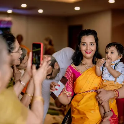 Everyone wants a picture of the little star. I love capturing these candid moments at events like naming ceremonies, where the whole family is celebrating together.