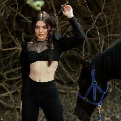 A model poses with one of my black horses during a professional fashion photoshoot at our facility.