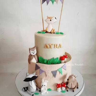 A stunning two-tier woodland animal cake for a first birthday. I loved creating the sweet, handcrafted fox, raccoon, owl, and deer to bring this gentle forest scene to life.