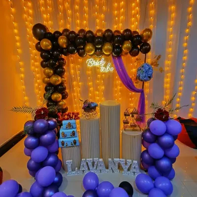 A beautiful 'Bride to be' decoration with a purple and black theme. The square balloon arch, fairy light curtain, and personalized name sign create a stunning backdrop for the celebration.