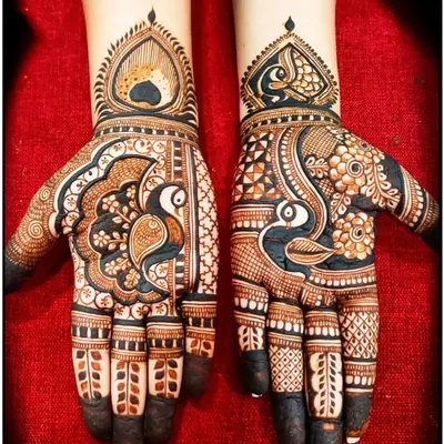 A striking example of Rajasthani art with bold peacock motifs. The contrast between the dark-filled figures and the delicate patterns on the fingers makes this design stand out.