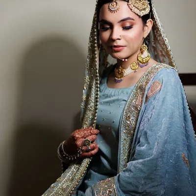 Doesn't she look like a Shehzaadi? This is a classic Nikah look, featuring soft, warm-toned eyeshadow, flawless skin, and traditional jewelry that completes the royal vibe.