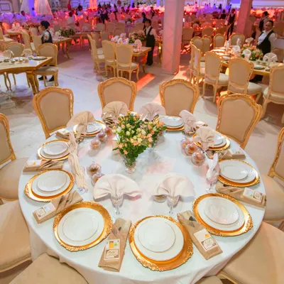 A view of a breathtaking wedding setup we curated. The grand table arrangement with gold accented chairs and pristine white linens creates an atmosphere of pure luxury and sophistication, perfect for a high end celebration.
