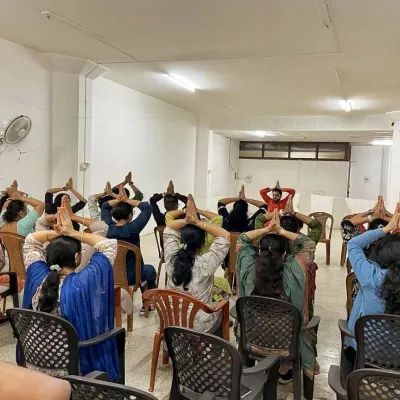 We guide employees through chair yoga postures during a session at National Insurance. These exercises are specifically designed to be performed at a desk, helping to release tension in the neck, shoulders, and back caused by prolonged sitting.