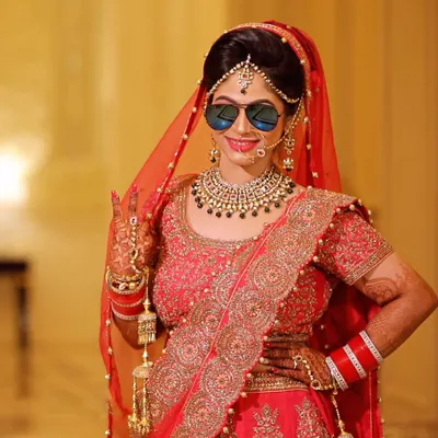 A fun and modern bridal portrait. The bride adds a touch of swag with sunglasses, showing that wedding photos can be both beautiful and full of personality.