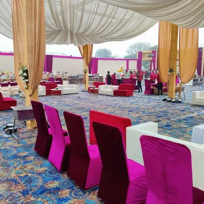 For large receptions, I provide comfortable lounge furniture. This setup includes plush white sofas and high-back chairs in pink and red velvet, arranged for conversation.