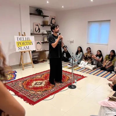 A poet takes the stage in our packed studio. We often have to pull out extra carpets to fit everyone, a testament to the incredible enthusiasm of the DelSlam fam.