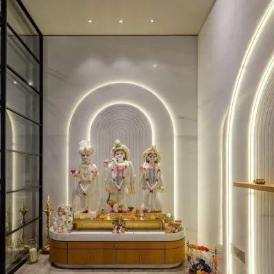This minimalist mandir design makes a statement with concentric, illuminated arches that create a modern halo effect. The clean white marble walls and a sleek wooden base with gold trim offer a contemporary setting for the deities.