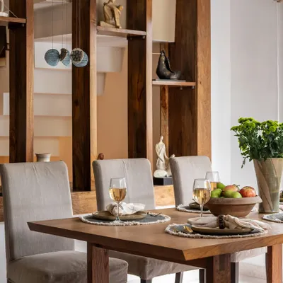 Comfort served with craftsmanship. This dining space features a solid wood table and a built-in shelving unit that acts as both art and architecture, showcasing handpicked accents that echo the room's quiet sophistication.