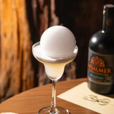 The moment before the magic. This gin cocktail with a smoke bubble is all about building anticipation, a perfect shot for a dramatic social media reveal.