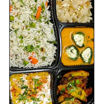 A complete and satisfying 'Happy Meal' featuring my special Palak Paneer Kofta, vegetable pulao, boondi raita, masala aloo, and a sweet dry fruit sheera.