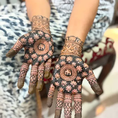 This design features a central mandala with a lucky elephant motif, surrounded by lotus patterns. The dark, filled-in background makes the main design really stand out.