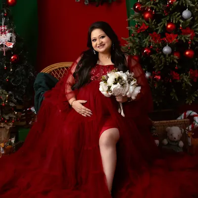 We can celebrate any season. This festive Christmas-themed maternity shoot uses a rich red gown and holiday decor to create a warm and magical portrait.
