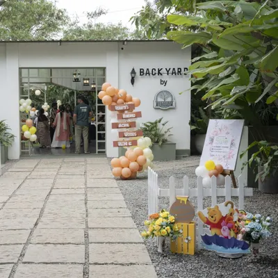 Welcome to the Hundred Acre Wood! The entrance to this Winnie the Pooh party at a beautiful farmhouse venue featured a rustic directional sign and Pooh-themed props.