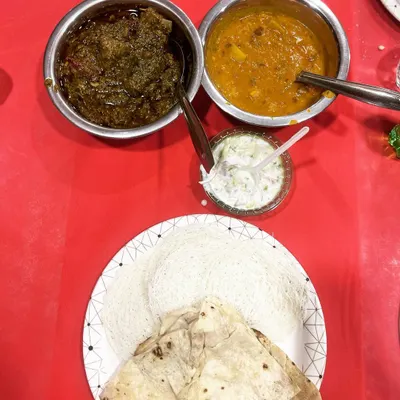 A classic combination of Bhaji Gosht (mutton with spinach) and dal, served with soft rumali roti. This is a hearty and traditional meal option.