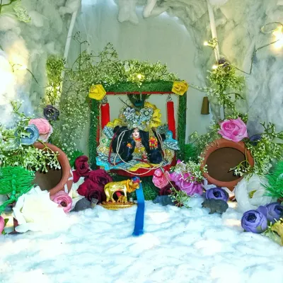 This is a detailed Janmashtami jhanki I made. The small diorama for Bal Gopal is set in a cave-like structure, decorated with greenery, flowers, and tiny matkas to depict scenes from Krishna's life.