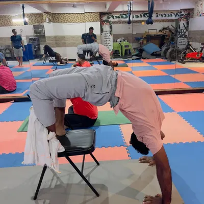 Using a chair for support allows for a much deeper and safer backbend in Chakrasana (Wheel Pose). This method helps open the chest and shoulders without putting pressure on the wrists or lower back.
