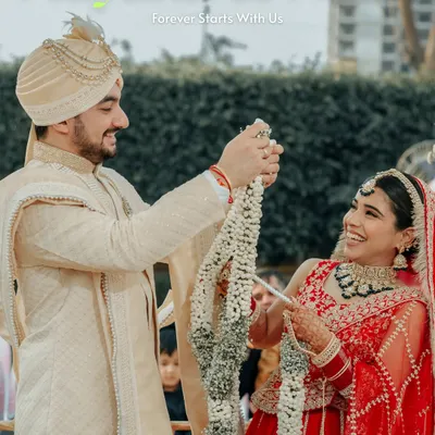 A moment of pure joy during the Varmala ceremony. Mayank and Neha's laughter is infectious as they playfully exchange garlands, a perfect candid shot.