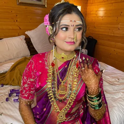 Representing tradition to ultimate perfection. This Maharashtrian bridal look features a classic 'mundavalya', a 'nath', and beautiful pink and purple tones in her makeup to match her Paithani saree.