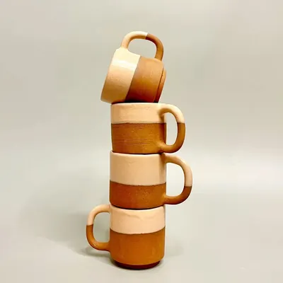 This stack of two-tone mugs showcases the beauty of raw terracotta clay paired with a smooth, light glaze. They are designed for daily use, bringing a touch of handmade artistry to your coffee or tea.