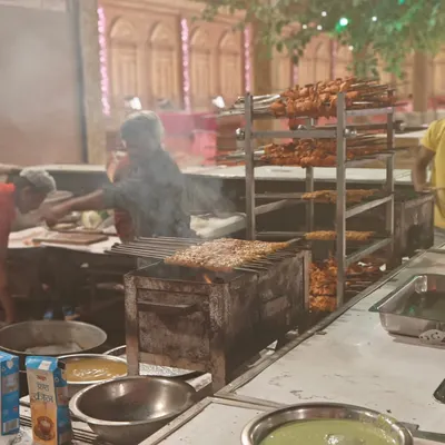 Our live kebab station in full swing. The smoke and aroma of freshly grilled chicken tikkas and seekh kebabs create a fantastic atmosphere at any party.
