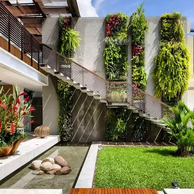 An ambitious outdoor vertical garden that spans multiple stories along a staircase. This design turns a functional architectural element into a breathtaking living feature, with different sections showcasing a variety of plant textures.