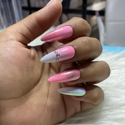 An example of a custom press-on nail set. This design features a mix of pink chrome, a white-to-pink ombre with a rhinestone accent, and a full iridescent nail.