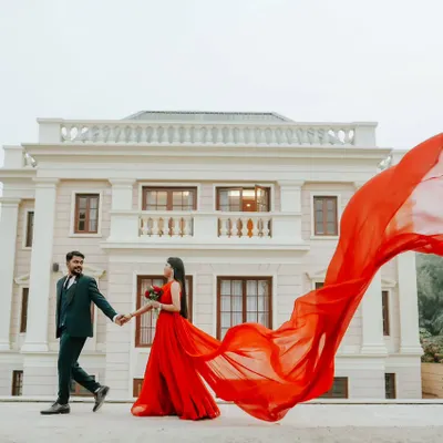 A signature pre-wedding shot. The flowing red gown against the magnificent architecture creates a dramatic, movie-like feel that turns your love story into an epic tale.