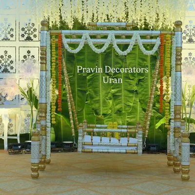 This is a full view of a naming ceremony stage I designed. The centerpiece is the traditional palna, decorated with marigold and jasmine garlands, set against a fresh banana leaf backdrop and white floral panels.