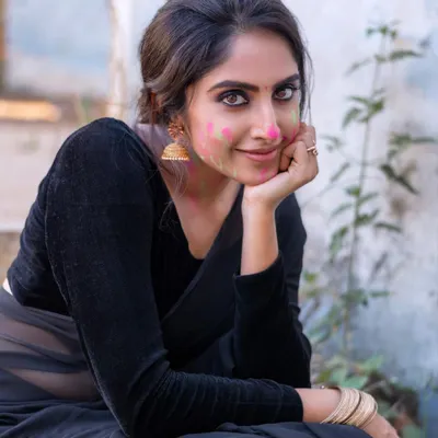 A beautiful portrait from our 'Holi Hai' concept shoot. The contrast between the elegant black saree and the playful smear of pink gulal on her cheek creates a unique and modern take on festival photography.