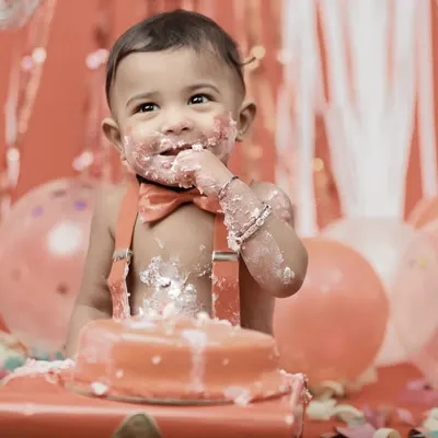 There's nothing quite like the moment they first taste the cake. This close up captures the pure delight and sweet mess of a first birthday cake smash session.