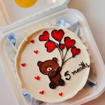 A sweet bento cake for a 5-month celebration, featuring a hand-piped teddy bear holding a bouquet of heart-shaped balloons.