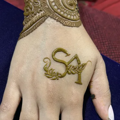 A close-up of the personalized initials "SA" on the back of the hand, a beautiful and elegant touch for any bride.