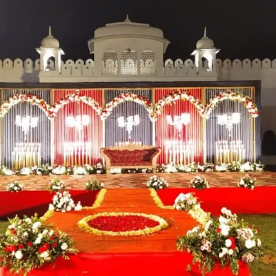 A magnificent wedding stage set against a heritage property, blending royal architecture with classic red and white decor for a timeless look.