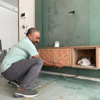Dust, drills, and design dreams. This is the 'trust the process' phase, where our carpenter is meticulously installing a custom TV unit.
