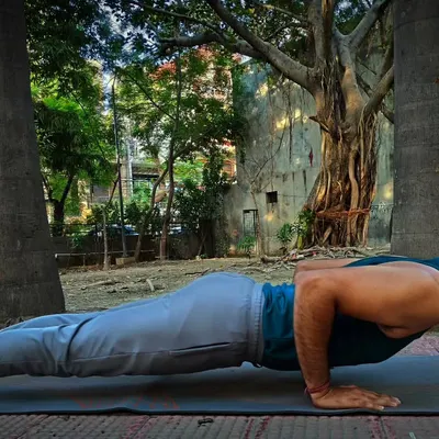 Holding the Chaturanga Dandasana pose. This yoga asana is excellent for building strength in the arms, shoulders, and core muscles while also improving focus and stability. It is all about control.
