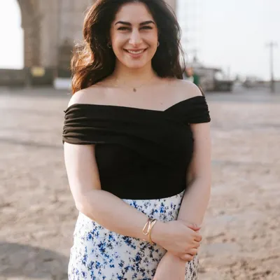 A warm, welcoming portrait taken at the Gateway of India. The soft morning light and her friendly smile make this a perfect shot for a personal or professional profile.