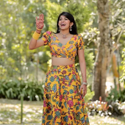 A happy moment in our yellow floral kalamkari lehenga set. This two-piece outfit is perfect for mehendi functions or festive daytime events.