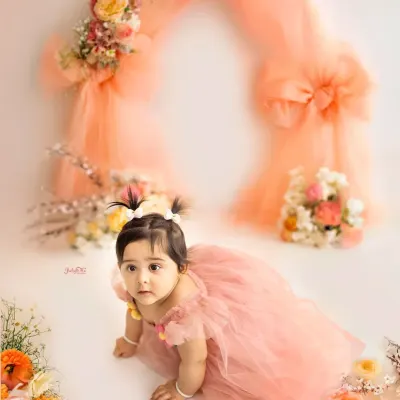 This little princess is crawling through a garden of peach-coloured flowers and tulle. It’s such a soft and delicate setup for a baby girl’s first birthday portraits.