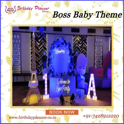 A stylish Boss Baby theme party featuring a cool blue lighting scheme. The setup includes a life-size character cutout, marquee letters, a miniature Eiffel Tower prop, and a custom "Welcome to the Boss Party" sign.