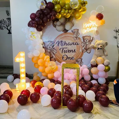 A warm and inviting teddy bear theme for Mihana's first birthday. This setup features a custom backdrop, a large light-up number '1', a teddy bear prop, and a balloon arch in rich, earthy tones.