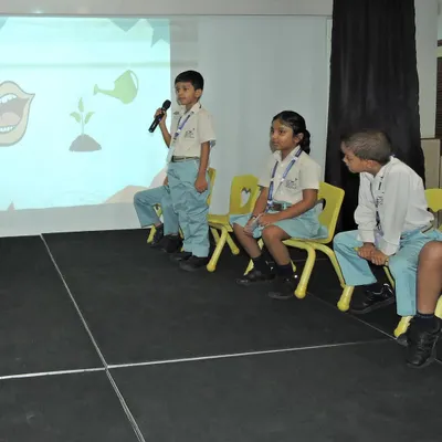 A student confidently takes the microphone during our "Buzzathon" spelling competition. We create opportunities like this to help children build vocabulary and gain confidence in public speaking.